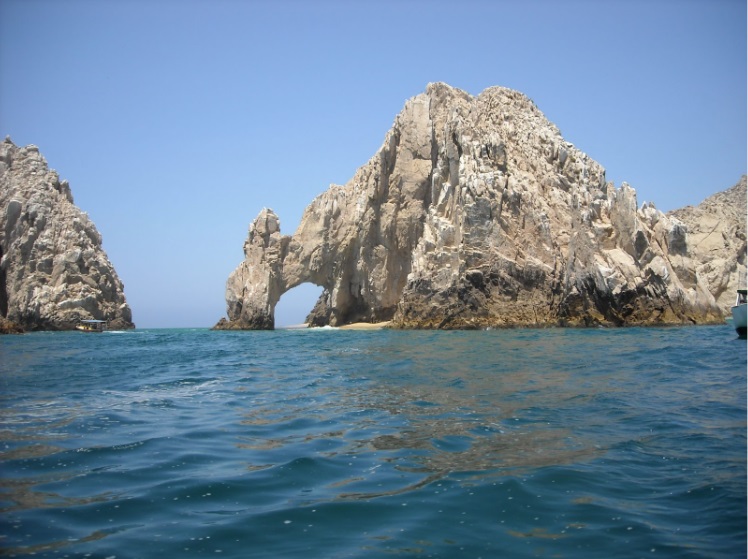 Lands End in Cabo San Lucas - two rocks, one with an archway. The photo is taken from a boat and shows a clear sky and sea.